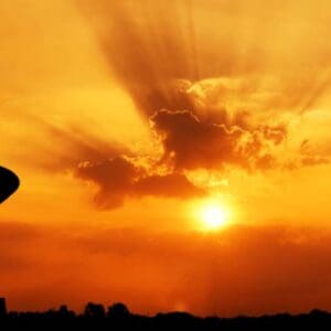 A person standing in front of the sun.