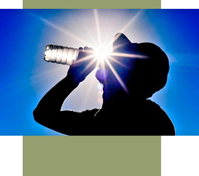 A person drinking water from a bottle in the sun.